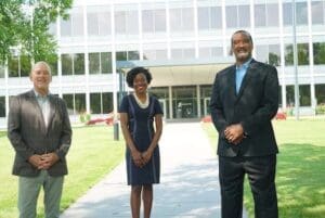 Three business people standing in front of a building.