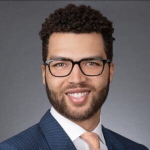 A man in a suit and tie smiling.