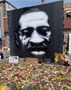 A painting of a black man is surrounded by flowers.