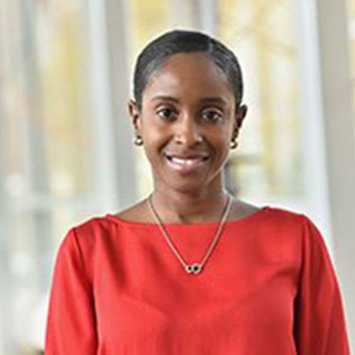 A woman in a red top smiling for the camera.