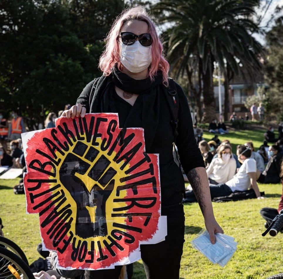 Woman holding a "Black Lives Matter" sign.