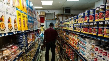 Man shopping in a grocery store aisle.