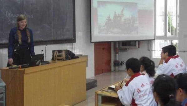 A woman lectures students in a classroom.