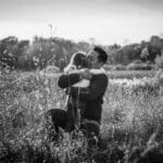 Man and daughter hug in a field.