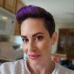 Woman with purple hair and makeup.