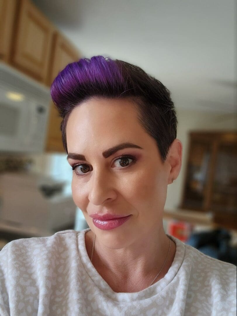 Woman with purple hair and makeup.