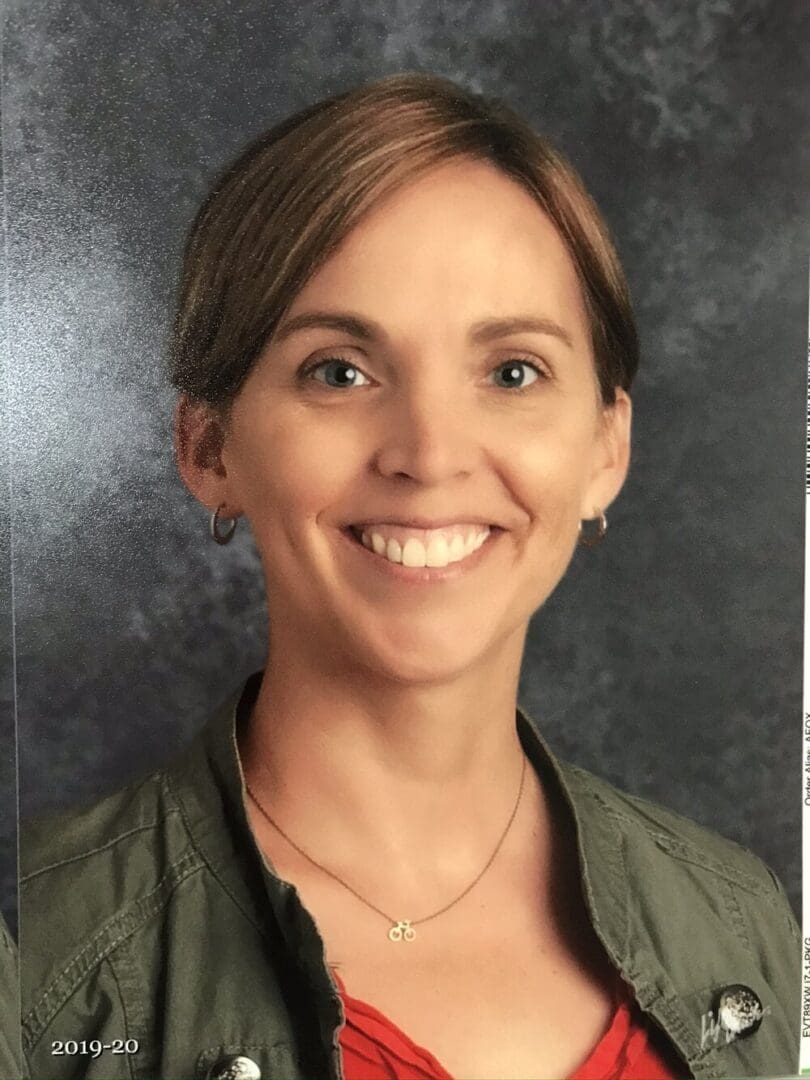 Headshot of a smiling woman in a green jacket.