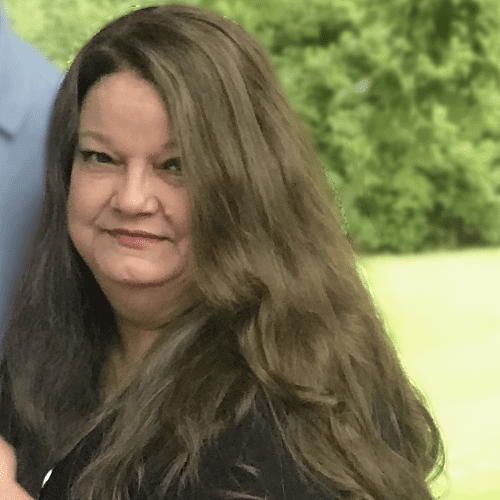 Woman with long brown hair smiling.