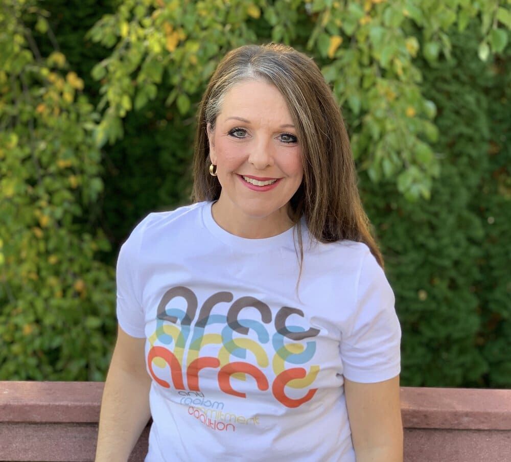 Woman wearing a white t-shirt with a logo.