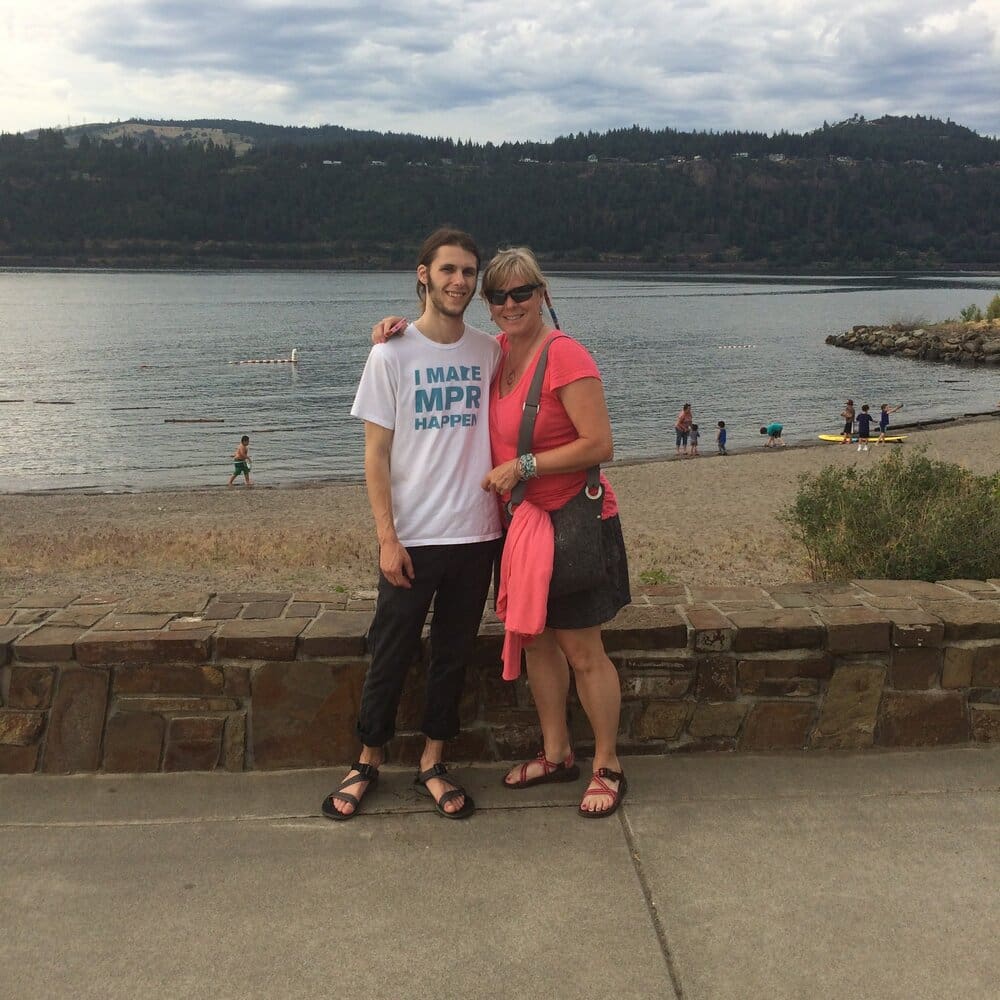 A man and woman smiling at the beach.