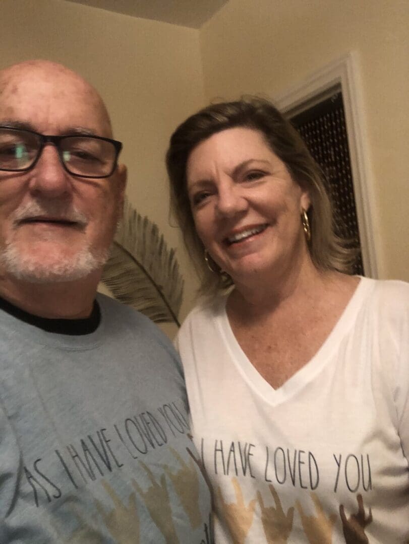 Couple wearing shirts with "As I have loved you"