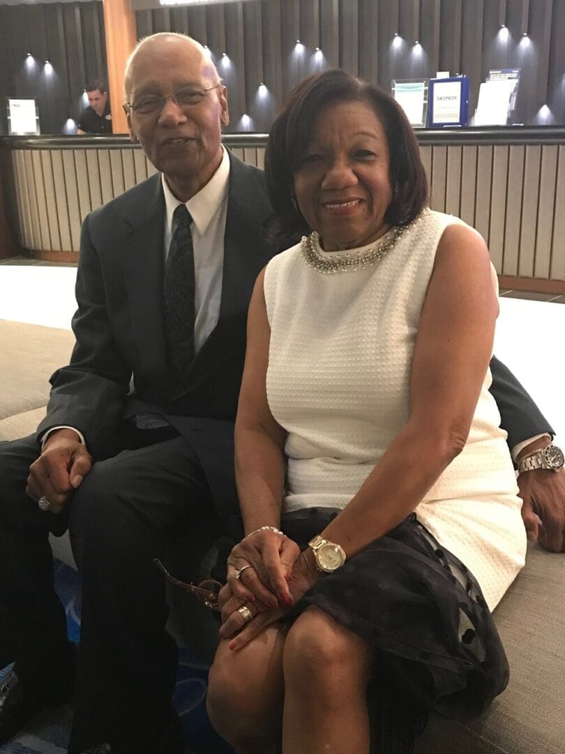 An older couple sitting together, smiling.