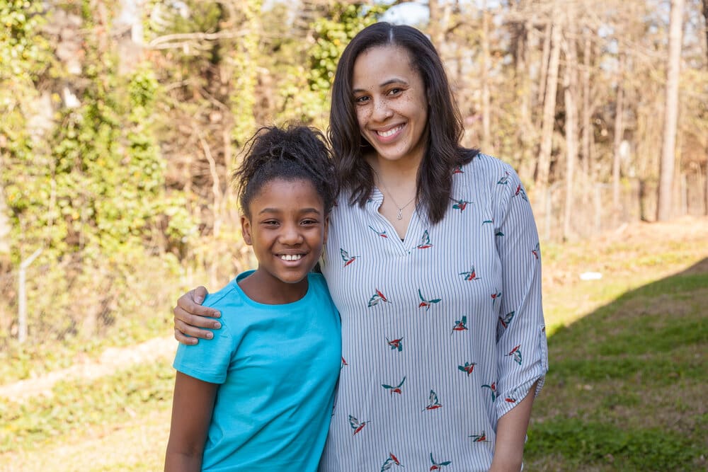 Smiling mother and daughter in a park.