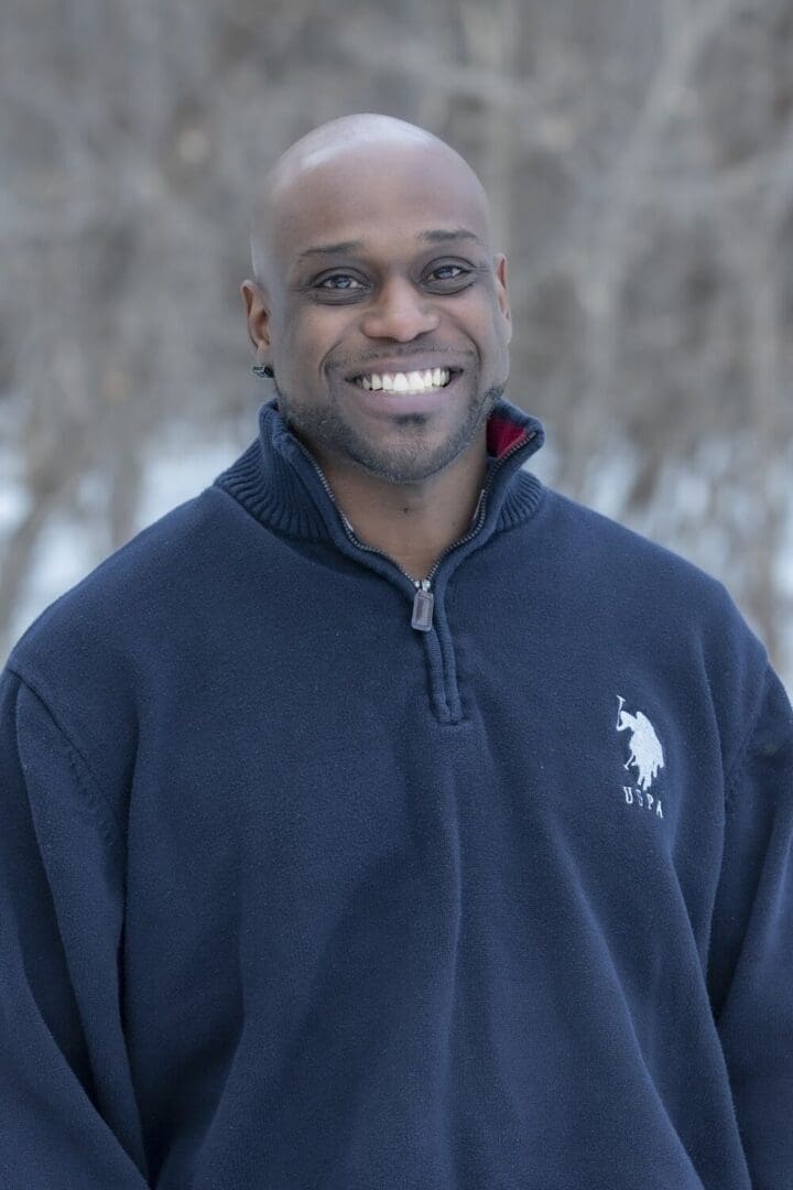 Smiling man in a blue sweater.