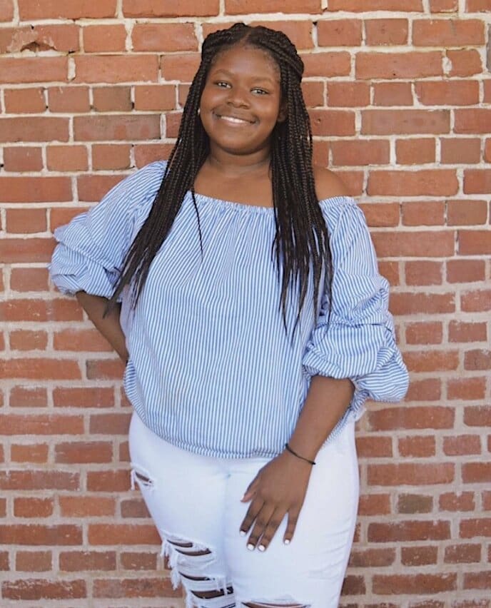 Woman in striped shirt and white jeans.