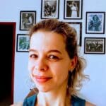 Smiling woman in front of music posters.