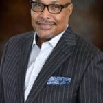 Man in a striped suit with a pocket square.