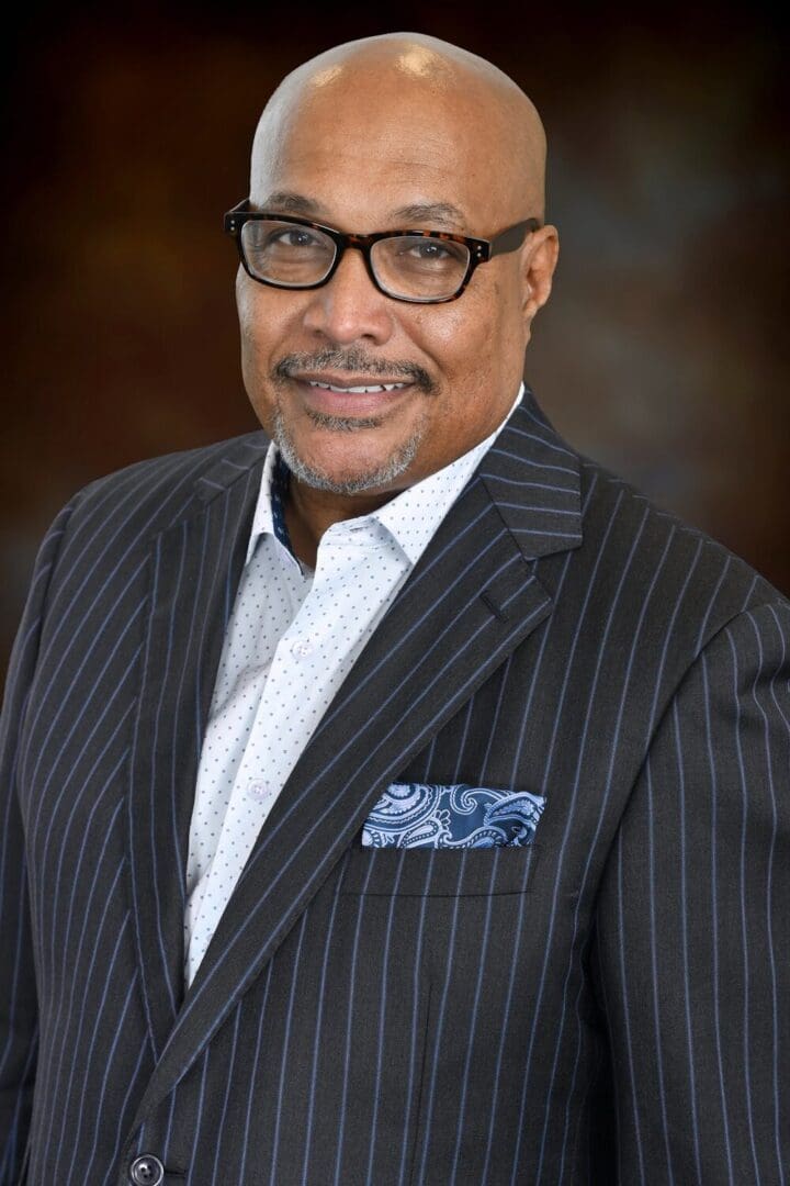 Man in a striped suit with a pocket square.