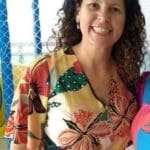 Woman in floral dress smiling at camera.