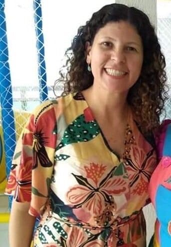 Woman in floral dress smiling at camera.