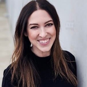 A woman with long dark hair smiling.