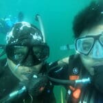 Two scuba divers underwater with gear.