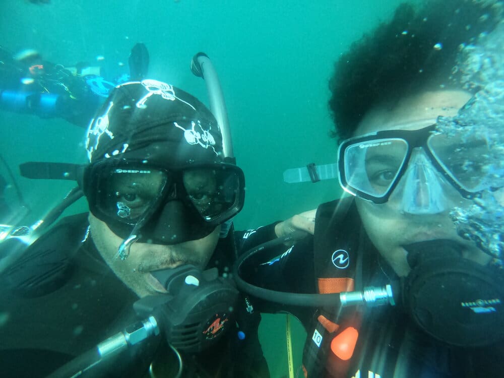 Two scuba divers underwater with gear.