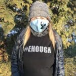 Woman wearing a #ENOUGH shirt and a mask.