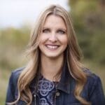 Smiling woman in a denim jacket.