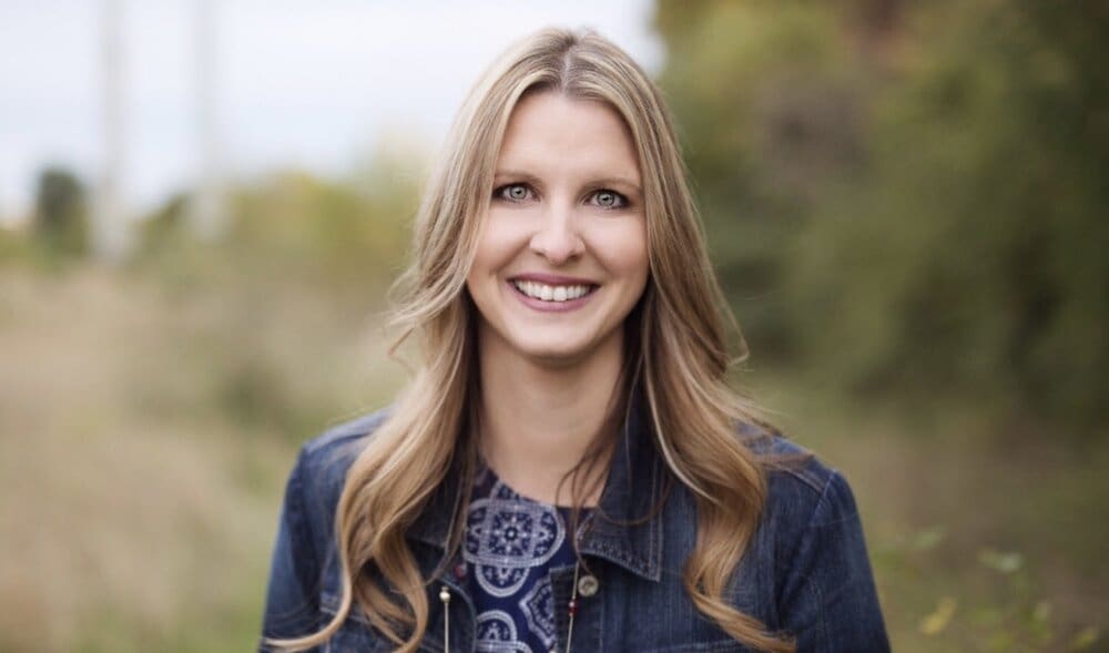 Smiling woman in a denim jacket.