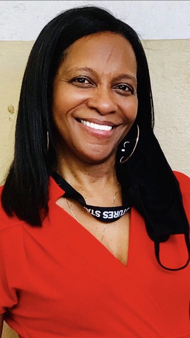 Woman smiling in red dress with lanyard.