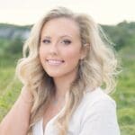 Smiling woman with blonde hair in a field.