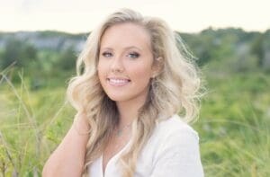 Smiling woman with blonde hair in a field.