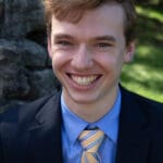 Smiling man in a blue suit and tie.