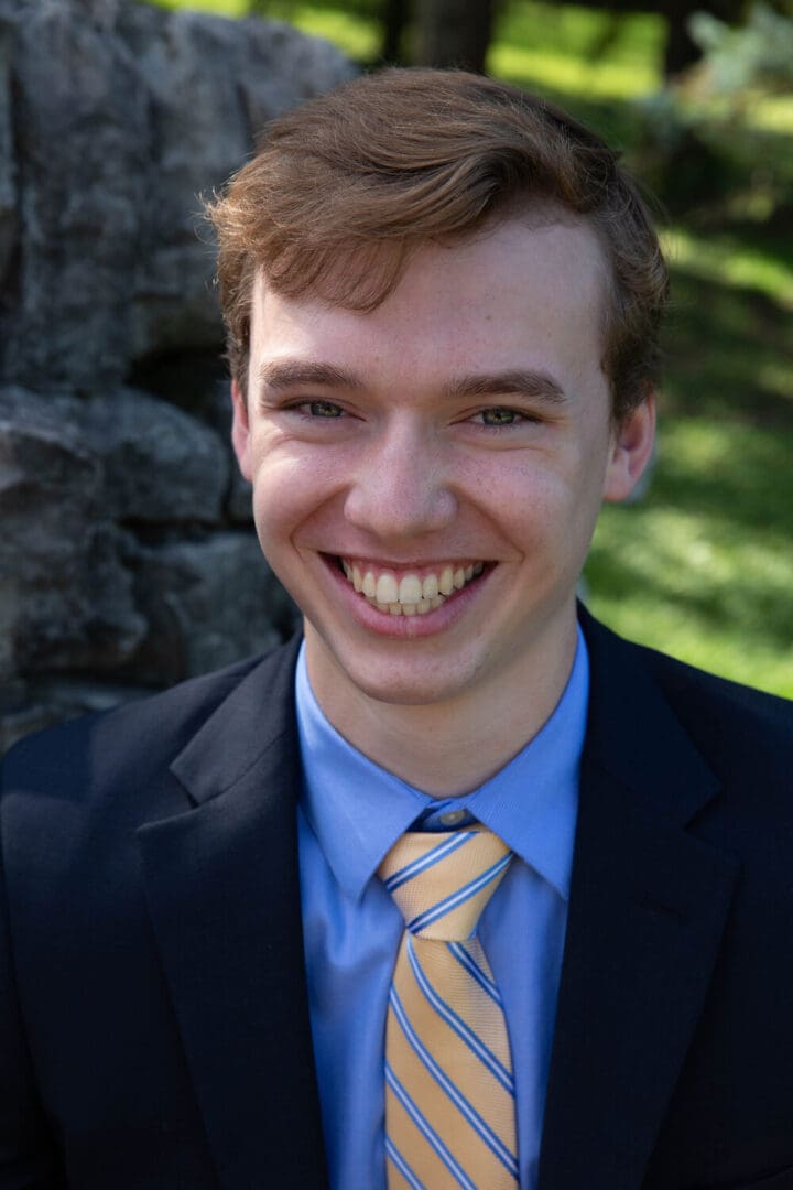 Smiling man in a blue suit and tie.