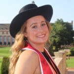 Smiling woman in a graduation gown and hat.