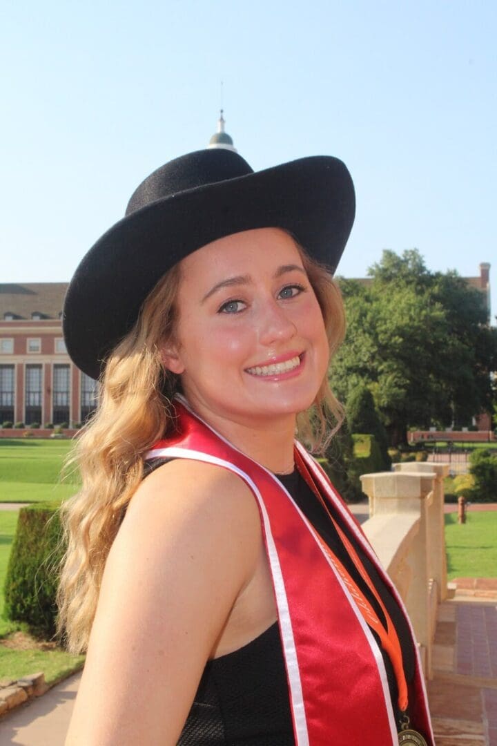 Smiling woman in a graduation gown and hat.