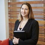 Smiling businesswoman holding a binder.