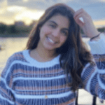 Smiling woman in striped sweater with long brown hair.