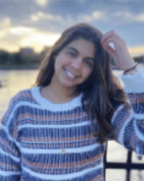 Smiling woman in striped sweater with long brown hair.