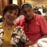 Smiling couple sitting at a restaurant table.