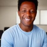 Smiling man wearing a blue t-shirt.