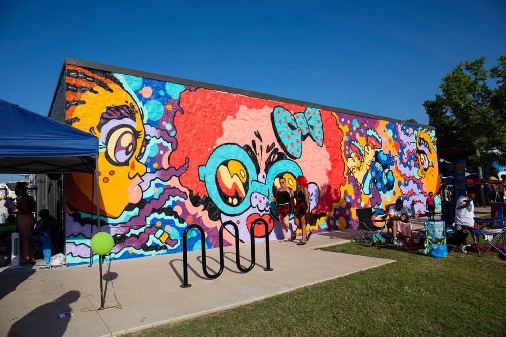 A vibrant mural adorns the side of a building, showcasing a blend of colors and artistic designs that captivate the viewer.