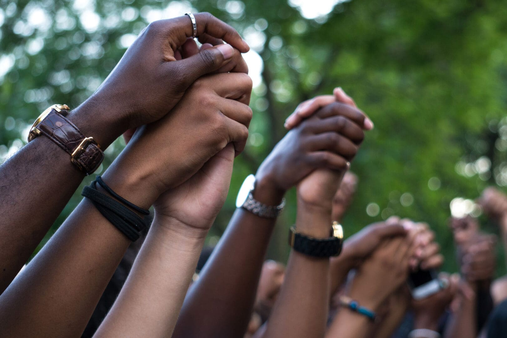 A collective of people from various backgrounds, joined in a circle, holding hands to represent solidarity and connection.