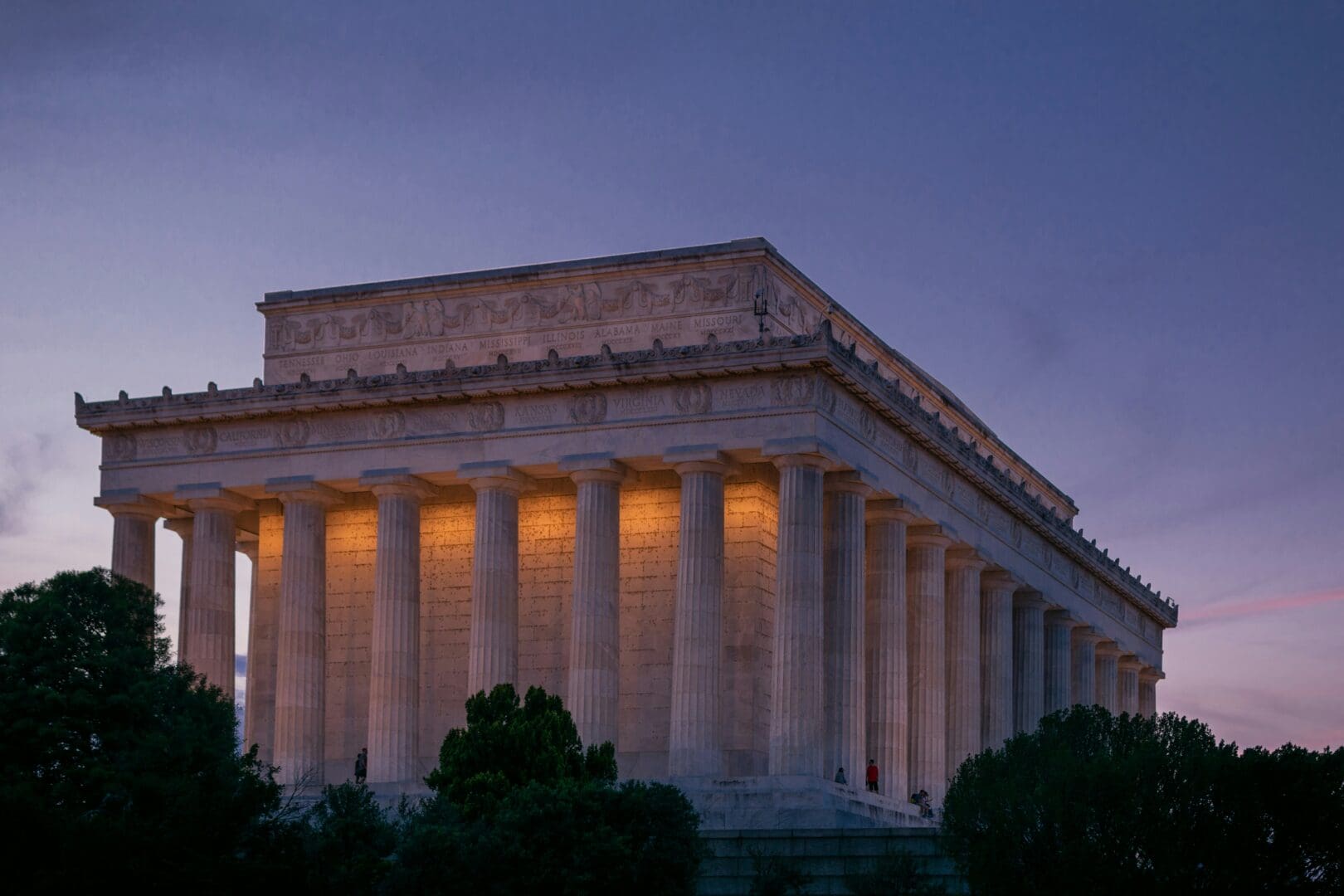 The Lincoln Memorial illuminated at dusk, showcasing its iconic columns against a twilight sky.