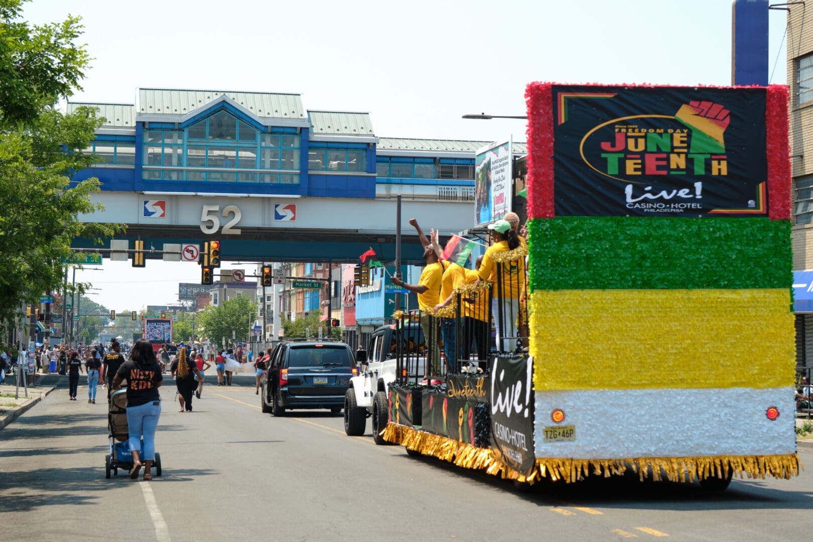 A grand float embellished with bright green, yellow, and red decorations, creating a lively and celebratory atmosphere.