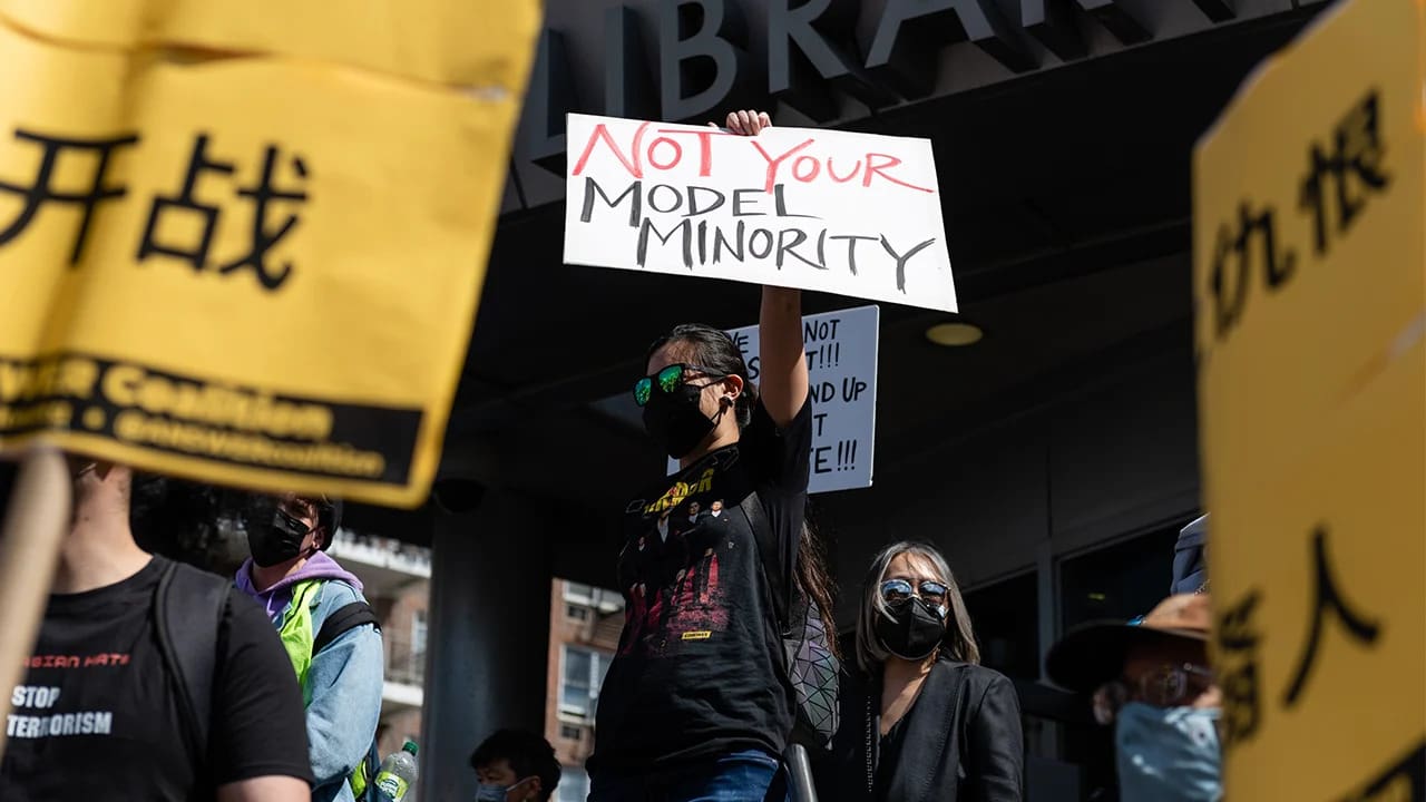 Protesters gather in front of a building, holding signs that convey their messages and demands for change.