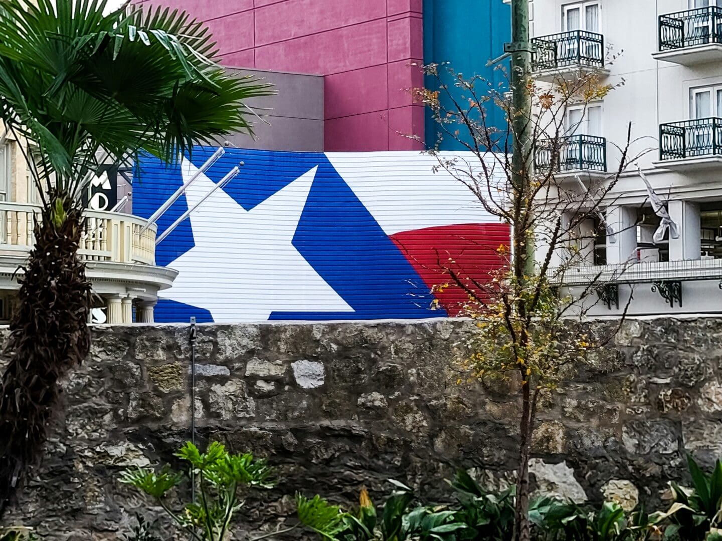 A large flag is prominently displayed on the side of a building, showcasing vibrant colors and intricate details