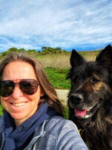 A Woman Smiling With A Black Dog