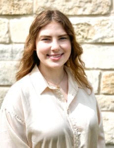 A woman wearing white and smiling